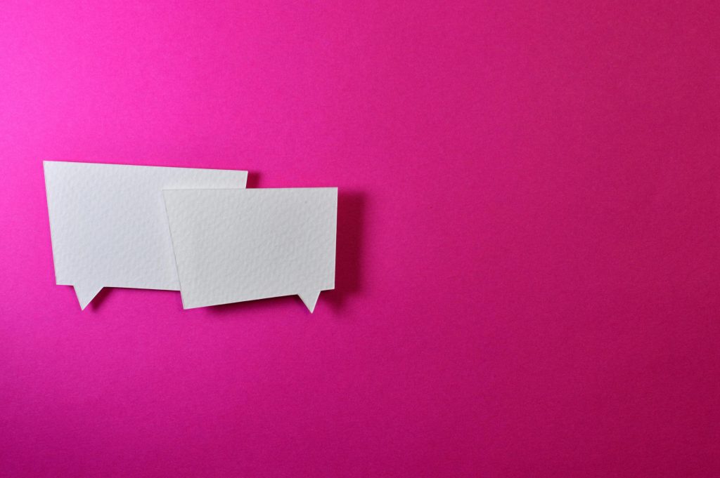 White speech bubbles on a vibrant pink background for communication or design concepts.