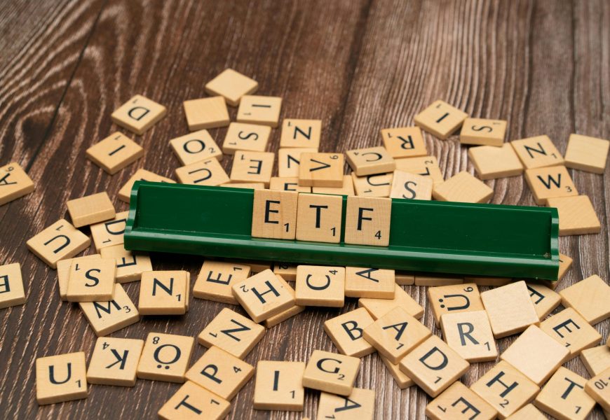 Wooden tiles spelling ETF on a game holder, representing investment themes.
