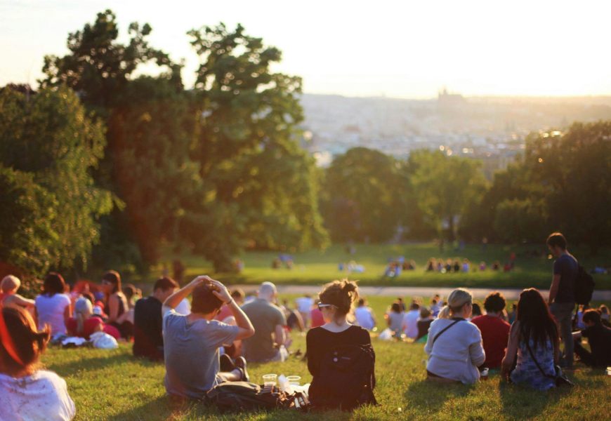 People relaxing and enjoying a sunny day in a bustling city park.