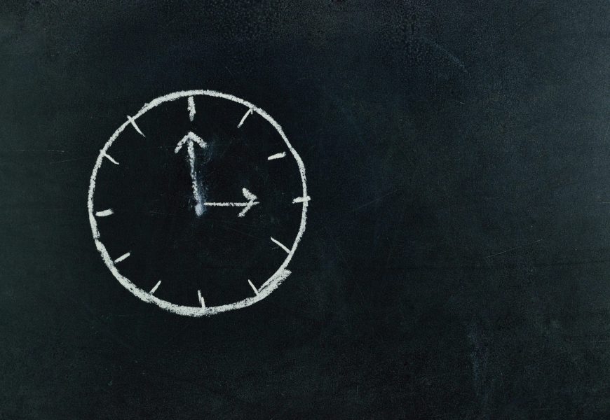 Chalk-drawn clock on a blackboard, symbolizing time and education concepts.